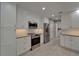Open concept kitchen showcases white cabinets, stainless steel appliances, granite countertops, and tile flooring at 9410 Alanbrooke St, Temple Terrace, FL 33637