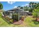 This property features a screened-in pool and lanai surrounded by landscaping and trees at 9410 Alanbrooke St, Temple Terrace, FL 33637