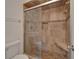 Modern tiled shower with glass door, built-in niche, and shower seat at 9410 Alanbrooke St, Temple Terrace, FL 33637