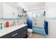 Cozy bathroom featuring a vanity with storage, a tub with shower, and a blue color scheme at 9469 Treasure Ne Ln, St Petersburg, FL 33702