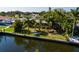 Waterfront home with mature palm trees overlooking the canal on a sunny day at 9469 Treasure Ne Ln, St Petersburg, FL 33702