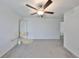 Spacious bedroom featuring gray carpet, neutral walls, modern fan and updated lighting at 9914 Calypso Orchid Ct, Riverview, FL 33578