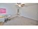 Bright bedroom featuring gray carpet, ceiling fan, and modern decor, creating a cozy atmosphere at 9914 Calypso Orchid Ct, Riverview, FL 33578