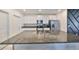 Modern kitchen featuring granite countertops, a stainless steel refrigerator, and sleek white cabinetry at 9914 Calypso Orchid Ct, Riverview, FL 33578