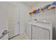 Functional laundry room featuring washer, dryer, and storage shelf at 9914 Calypso Orchid Ct, Riverview, FL 33578