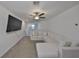 Upstairs loft living room featuring large sectional sofa, a ceiling fan, natural light, and carpeted floors at 9914 Calypso Orchid Ct, Riverview, FL 33578