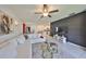 Bright, open-concept living room with modern decor, a stylish geometric accent wall, and neutral-toned furniture at 9914 Calypso Orchid Ct, Riverview, FL 33578