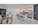 Open-concept kitchen and dining area with white cabinets, a large island, and an adjacent living room at 9914 Calypso Orchid Ct, Riverview, FL 33578