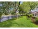 Tranquil backyard with lush landscaping, a black fence, and a serene pond view from the manicured lawn at 2207 Climbing Ivy Dr, Tampa, FL 33618