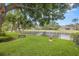 The manicured lawn features a black fence, bench, potted plant, and a serene pond view at 2207 Climbing Ivy Dr, Tampa, FL 33618