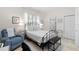 Bright bedroom with a metal bed frame, white bedding, and an accent chair with soft natural light at 2207 Climbing Ivy Dr, Tampa, FL 33618