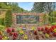 Stone entrance sign for Deer Creek community, surrounded by colorful flowers and greenery at 2207 Climbing Ivy Dr, Tampa, FL 33618