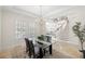 Bright dining room with glass table, staircase view, and natural light streaming through the windows at 2207 Climbing Ivy Dr, Tampa, FL 33618
