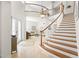 Elegant foyer featuring a grand staircase, travertine floors, and open views to the living area at 2207 Climbing Ivy Dr, Tampa, FL 33618