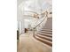 Spacious foyer with a curved staircase, stone floors, and an elegant chandelier creates a luxurious entry at 2207 Climbing Ivy Dr, Tampa, FL 33618