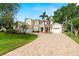 Beautiful two-story home showcasing lush landscaping, brick paver driveway, and a welcoming three-car garage at 2207 Climbing Ivy Dr, Tampa, FL 33618
