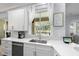 Bright kitchen featuring white cabinetry, stainless steel appliances, and quartz countertops with a window overlooking the backyard at 2207 Climbing Ivy Dr, Tampa, FL 33618
