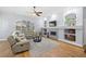Comfortable living room with fireplace, built-in shelving, modern ceiling fan, and hardwood flooring at 2207 Climbing Ivy Dr, Tampa, FL 33618