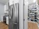 Spacious walk-in pantry with extensive shelving, providing ample storage space adjacent to stainless steel refrigerator and range at 2207 Climbing Ivy Dr, Tampa, FL 33618