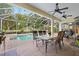 Covered patio features a dining table, chairs, and a view of the pool at 2207 Climbing Ivy Dr, Tampa, FL 33618