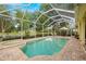 A gorgeous pool and spa are located in a screened lanai with a table and chairs for outdoor dining at 2207 Climbing Ivy Dr, Tampa, FL 33618