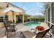 The screened-in lanai features a pool with sun loungers, as well as a dining table with chairs for relaxation at 2207 Climbing Ivy Dr, Tampa, FL 33618
