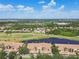 Aerial view of a lakeside community featuring townhomes, a golf course, and mature trees at 1003 Fairwaycove Ln # 103, Bradenton, FL 34212