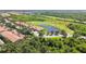 Aerial view features lush greenery, a community pond, and a golf course at 1003 Fairwaycove Ln # 103, Bradenton, FL 34212