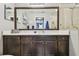 Bathroom vanity featuring rich wood cabinetry, white countertop, and large framed mirror reflecting the shower at 1003 Fairwaycove Ln # 103, Bradenton, FL 34212
