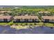 Aerial view of lakeside townhomes featuring tile roofs, well-maintained lawns, and palm trees at 1003 Fairwaycove Ln # 103, Bradenton, FL 34212