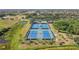 Overhead view of several community tennis courts with green and blue surfaces and trees at 1003 Fairwaycove Ln # 103, Bradenton, FL 34212