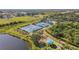 Aerial view showcasing multiple community tennis courts surrounded by lush landscaping and a playground at 1003 Fairwaycove Ln # 103, Bradenton, FL 34212