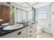 Bright bathroom features double sinks, black countertops, and white cabinetry at 101 N Taylor Rd, Seffner, FL 33584