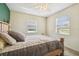 Bedroom with a wooden bed frame, plush bedding, and natural light from two windows at 101 N Taylor Rd, Seffner, FL 33584