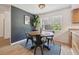 Modern dining area with a round wooden table, black chairs, and a dark accent wall at 101 N Taylor Rd, Seffner, FL 33584