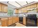 Bright kitchen features wooden cabinets and black appliances under a skylight at 101 N Taylor Rd, Seffner, FL 33584