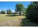 View of a red home and expansive yard bordered by trees, enhancing the property's curb appeal at 101 N Taylor Rd, Seffner, FL 33584