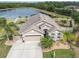 Aerial view of home with a large driveway, manicured landscaping, and a fenced backyard with lake views at 10911 Rockledge View Dr, Riverview, FL 33579