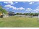 Well-manicured backyard features a screened-in pool area, white fence, and lake view at 10911 Rockledge View Dr, Riverview, FL 33579