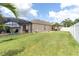 Expansive backyard with a screened-in lanai, white fence, and grill at 10911 Rockledge View Dr, Riverview, FL 33579