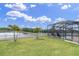 Spacious backyard with a white fence, a screened-in pool, and lovely water view at 10911 Rockledge View Dr, Riverview, FL 33579
