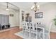 Open-concept dining room with wood floors, white table, and decorative light fixture at 10911 Rockledge View Dr, Riverview, FL 33579