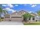 Charming one-story home with a 3-car garage, well-maintained landscaping, and tropical palm trees at 10911 Rockledge View Dr, Riverview, FL 33579