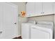 Bright laundry room features a white washer and dryer with overhead cabinets at 10911 Rockledge View Dr, Riverview, FL 33579