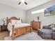 Bright bedroom with a wooden bed frame, natural light, and a cozy seating area, offering a relaxing retreat at 10911 Rockledge View Dr, Riverview, FL 33579