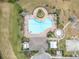 Aerial view of a community pool with lounge chairs, landscaping, and a basketball court at 10911 Rockledge View Dr, Riverview, FL 33579