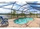Relaxing screened-in pool area with chairs overlooking a tranquil lake at 10911 Rockledge View Dr, Riverview, FL 33579