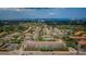 Wide aerial view of a multi-building residential complex with lush landscaping near coastal waters and distant cityscape at 1216 S Missouri Ave # 108, Clearwater, FL 33756