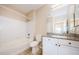 Bathroom featuring granite countertop vanity, shower, and large framed mirror at 1216 S Missouri Ave # 108, Clearwater, FL 33756