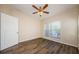 Comfortable bedroom with wood-look flooring, ceiling fan, and view from the window at 1216 S Missouri Ave # 108, Clearwater, FL 33756